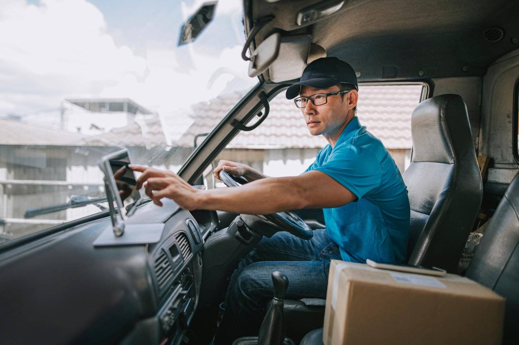 Delivery truck driver checking the tablet